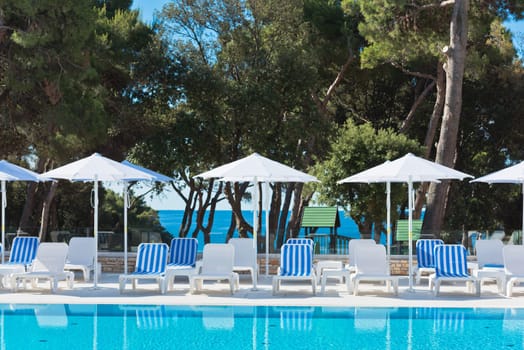 Hotel Poolside Chairs with Sea view. Summer shot