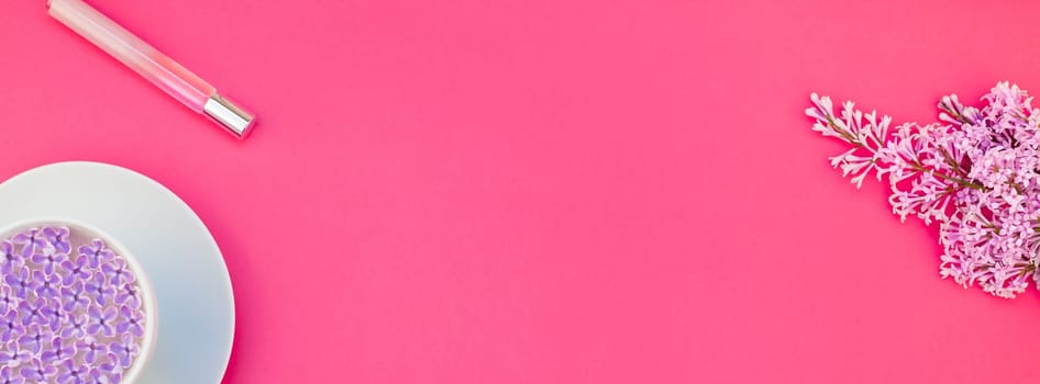 Creative top view flat lay of workspace desk styled design office supplies and cup of tea with copy space on a bright pink color paper long wide banner. Template for feminine blog social media
