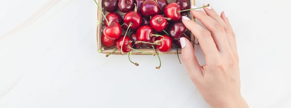 Long wide banner of fresh ripe cherry in a small wicker basket with copy space isolated white background minimal style. Concept of summer fun and healthy eating. Template for your text or food design