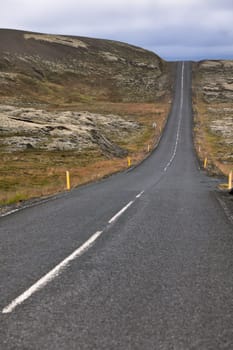 Highway through Iceland Mountain landscape at overcast day. Vertical shot