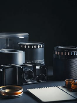 A collection of vintage camera equipment and film rolls on a dark background, evoking nostalgia.