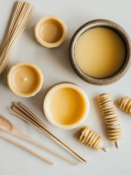 An assortment of natural beeswax products, including candles and honey, arranged artistically on a table.