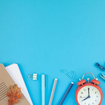 Square Creative flat lay top view back to school concept with alarm clock color school and office supplies on bright turquoise paper table frame background with copy space, template for text or design