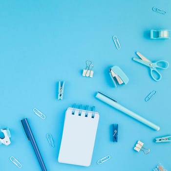 Top view flat lay of workspace desk styled design school and office supplies with copy space turquoise blue color paper background minimal style. Square Template for feminine blog social media