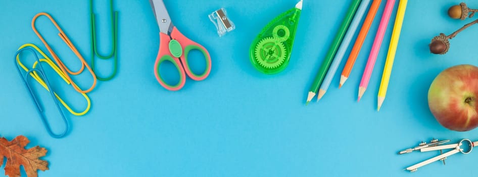 Creative flat lay top view back to school concept with color school and office supplies on bright turquoise paper table frame background with copy space, template for text or design. Long wide banner