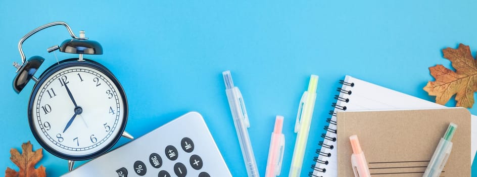 Creative flat lay top view back to school concept with color school and office supplies on bright turquoise paper table frame background with copy space, template for text or design. Long wide banner