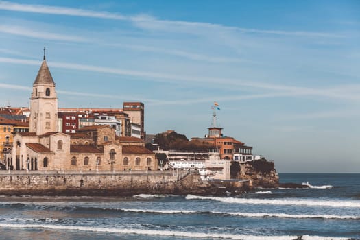 View of San Lorenzo ocean beach and San Pedro church in Gijon, Asturias, the Northern Spain