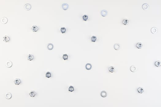 Creative Flat lay of metal nuts on white background. Repair or improvement top view concept pattern.