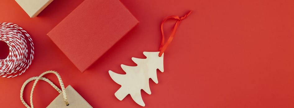 New Year or Christmas presents wrapped with ribbon flat lay top view Xmas 2019 holiday celebration handmade gift boxes on red paper background copyspace. Template mockup long wide banner design