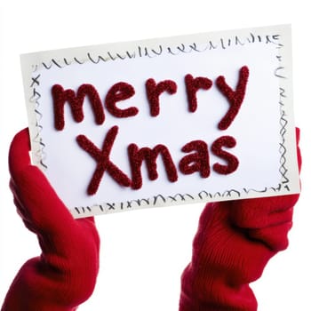 A pair of hands in bright red gloves holds a festive card wishing everyone a Merry Xmas decorated with glittery lettering.