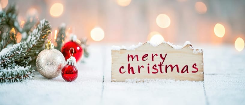 A cozy winter setting displays a Merry Christmas sign alongside ornaments and pine branches creating a warm holiday atmosphere.