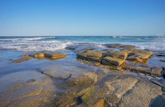 Surf waves breaking over the rocky headland at Point Cartwright at Kawana on Queensland's Sunshine Coast