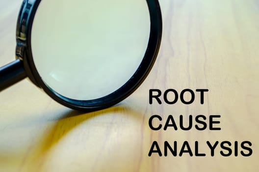 Root Cause Analysis text with magnifying glass background. Business solution concept.