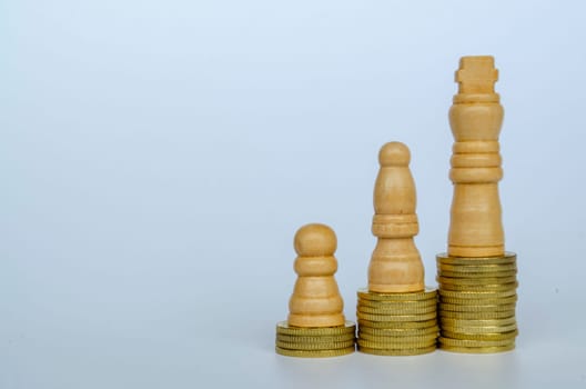 Chess pawns on top of golden stacking coins representing wealth and power with customizable space for text.
