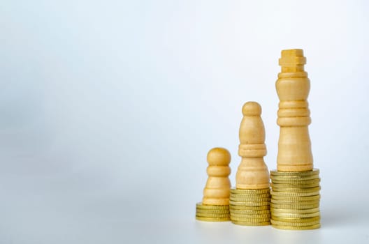 Chess pawns on top of golden stacking coins with customizable space for text or ideas.