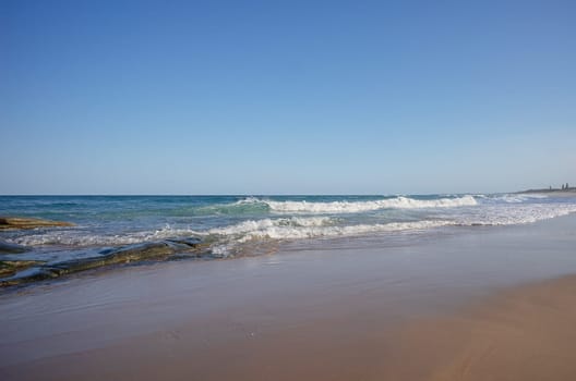 Surf waves breaking along the beach south from Point Cartwright, Buddina, Sunshine Coast, Queensland, Australia, a very popular holiday and tourist area.