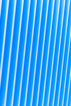 Detail of pattern striped metal facade for blue background