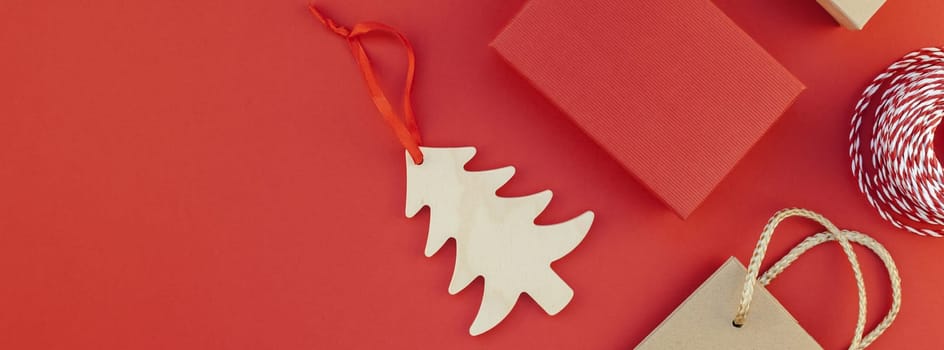 New Year or Christmas presents wrapped with ribbon flat lay top view Xmas 2019 holiday celebration handmade gift boxes on red paper background copyspace. Template mockup long wide banner design