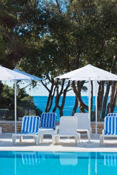Hotel Poolside Chairs with Sea view. Summer shot