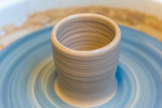 Pottering - creating a clay cup in process. Horizontal shot with a small GRIP