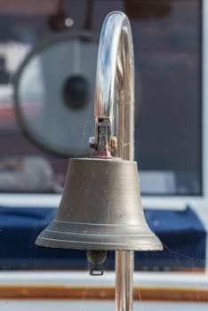 Brass ship bell on a classic sailboat. Close Up