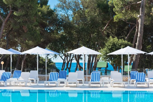 Hotel Poolside Chairs with Sea view. Summer shot