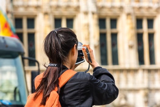 BELGIUM, BRUSSELS - MAY 25: Back side of a young woman taking a photo with her camera on May 25, 2015