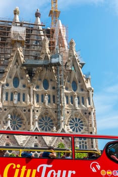 SPAIN, BARCELONA - SEPTEMBER 13: People sitting on a double decker tourist coach in front of The Sagrada Familia Cathedral in Barcelona on September 13, 2015