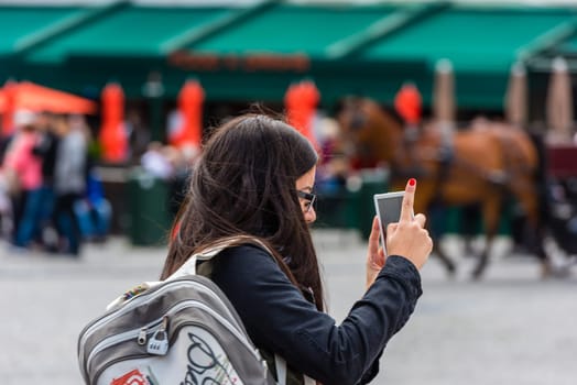 BELGIUM, BRUGES - MAY 22: Woman is taking pictures on the street of Bruges on May 22, 2015