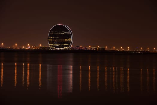 UAE, ABU DHABI - DECEMBER 20: View of Aldar headquarters building and night skyline of Abu Dhabi, UAE on December 20, 2014