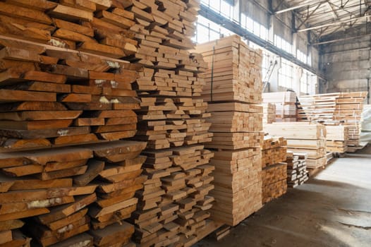 Stacked wooden planks close-up at lumber warehouse. Wood industry concept
