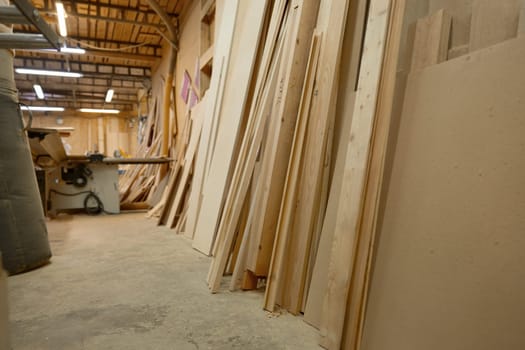 Woodworking interior with wood materials. Sawing logs and ending with grinding or fine carving on wood