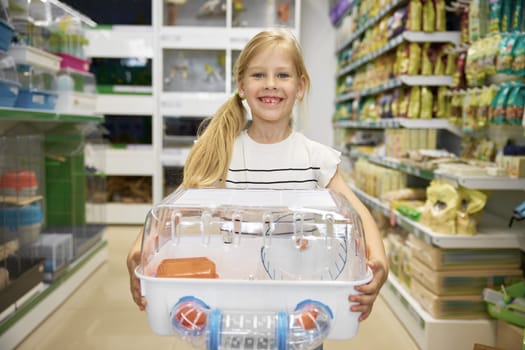 Portrait of cute smiling girl holding new cage for rodent pet purchased at vet supermarket