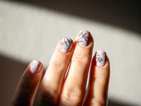 Female Hands With Light Pink Milky Aura Nails Manicure. Woman Fingernails With Pink Nails In Hard Sunlight Background. Floral Botanical Stamping. Aesthetic Visual Of Trendy Manicure With Nail Art.