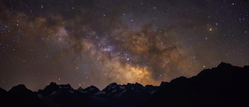 The galactic core of the Milky Way paints a vibrant backdrop above the silhouetted peaks of towering mountains.