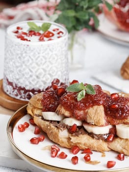 Croissant with chocolate, banana pieces and raspberry jam on a plate