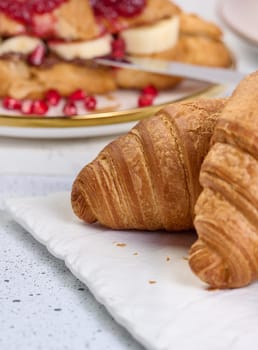 Baked croissants on white table, breakfast, close up