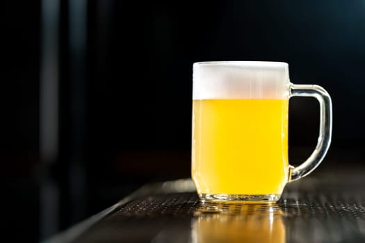Refreshing light beer on a bar top with condensation, perfect for quenching thirst in a relaxing pub setting
