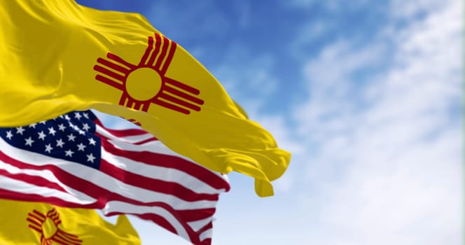 Close-up view of the New Mexico and United States flags waving in the wind on a clear day . 3d illustration render. Selective focus