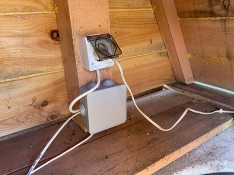 An image capturing the process of installing electrical wiring to a greenhouse, providing power for lighting, heating, and equipment.