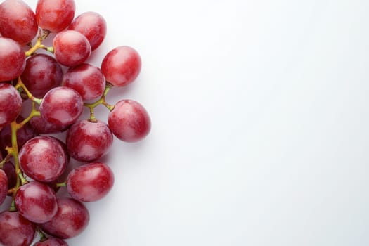 Vibrant plump grapes are neatly arranged against a bright white backdrop. The grapes showcase a glossy texture and rich color, emphasizing their freshness and natural appeal.