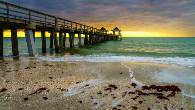 Pier and the beach in Naples, Florida, at sunset