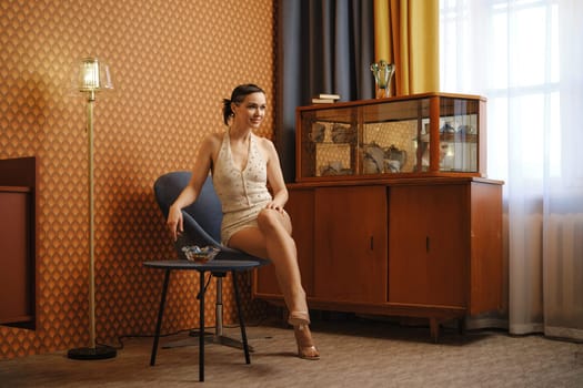 Elegant woman in vintage body suit sits in old-fashioned living room