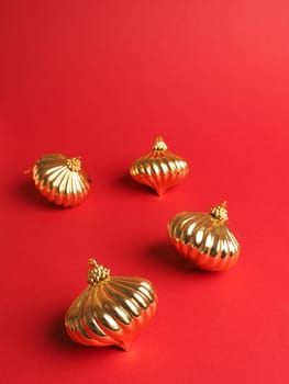 Golden Christmas baubles on a red background with space for your text