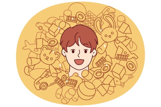 Face of teenager boy among toys and constructor for entertainment or development of child. Cheerful boy from kindergarten laughing enjoying happy childhood and abundance of toys for spending time