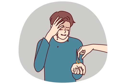 Crying man gets divorced and receives engagement ring from wife who cheated on husband and left for new boyfriend. Depressed husband suffers from depression after divorce and loss of beloved woman