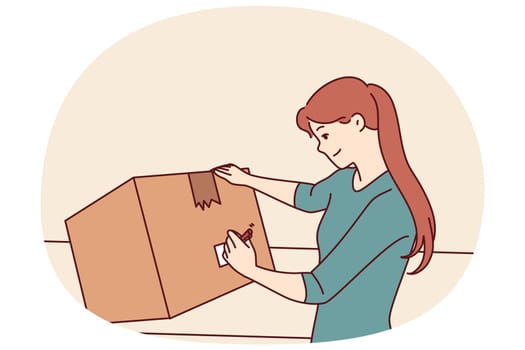 Woman with cardboard box signs package before sending goods through postal service or courier company. Young girl with big box packs household items when moving or renovating apartment