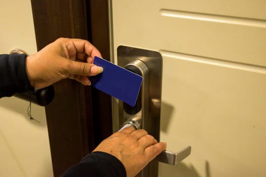 Hands holding a keycard near a door lock for entry, key electronic lock, hotel room, holidays in mallorca, spain