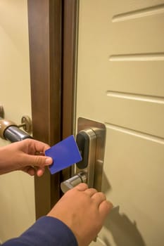 Close-up of a hand using a blue card key in a hotel door lock, key electronic lock, hotel room, holidays in mallorca, spain