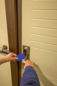 A hand inserting a blue card key into a modern hotel door lock, key electronic lock, hotel room, holidays in mallorca, spain